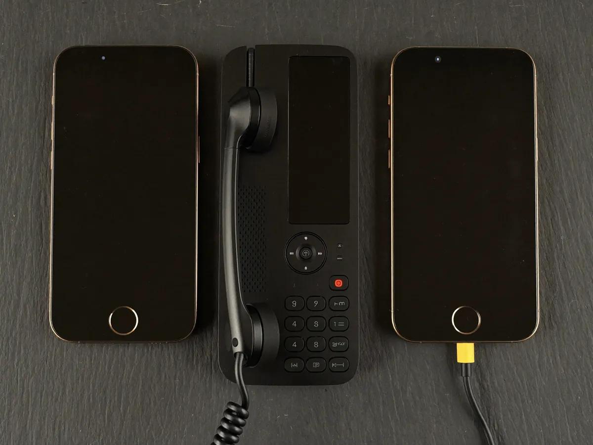 Smartphones, IP-telefoon en headset op een donkere ondergrond