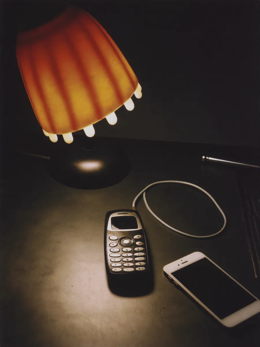 Oude en nieuwe mobiele telefoon naast elkaar op een bureau