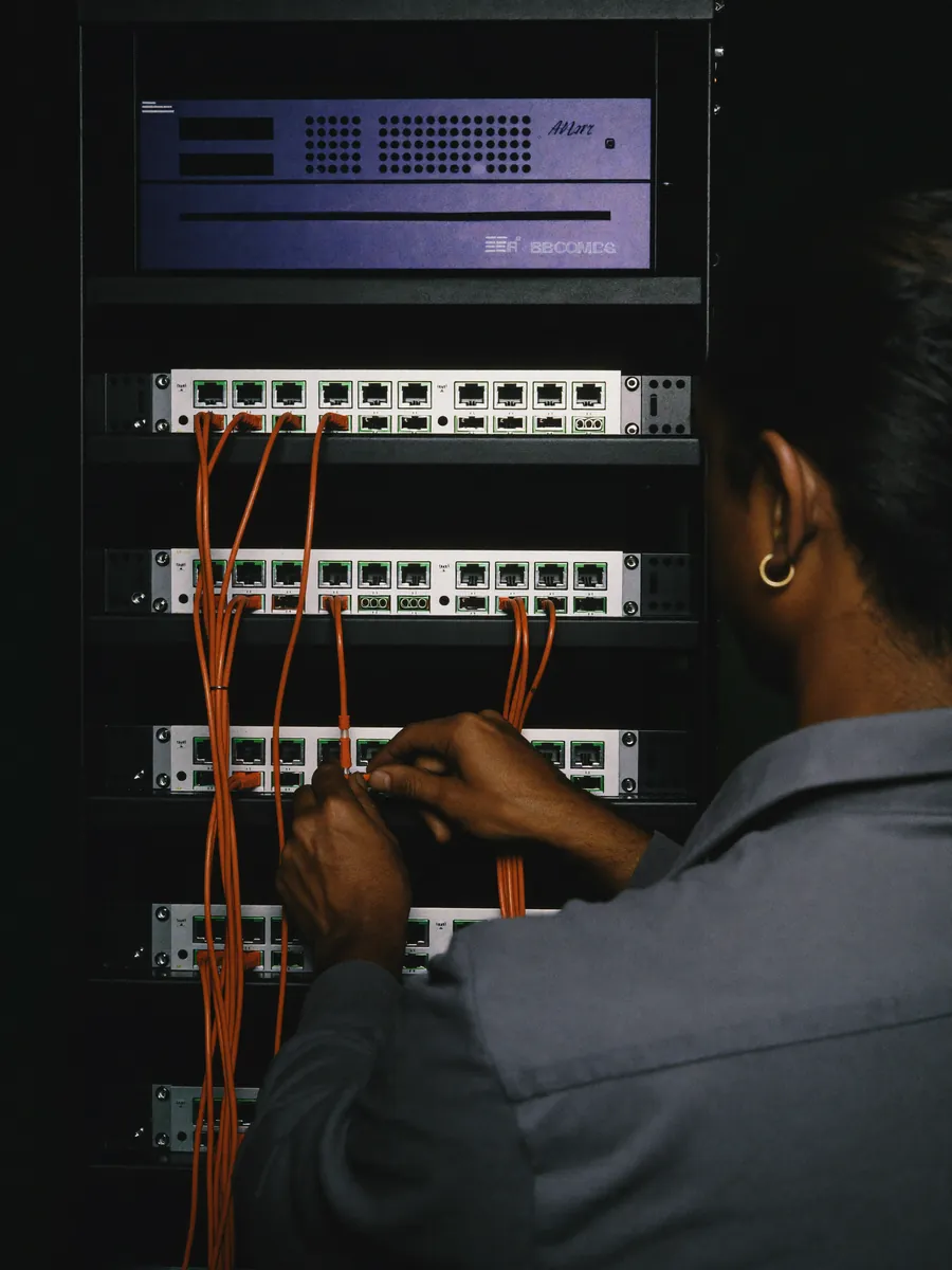 Netwerkbeheerder patcht kabels in een serverkast